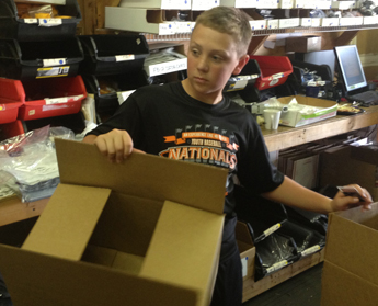 Ben Kirk picks up box in warehouse