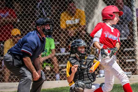 Umpire looks on as batter hits ball